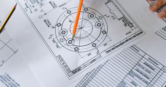 Career Development - From above of crop anonymous male with pencil in hand examining information on paper at table